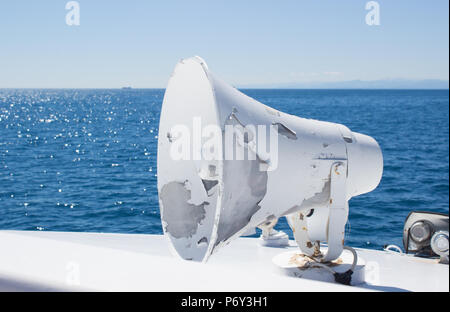 Horn Lautsprecher auf der Boot & blue sea water background/weiß Megafon mit blauen Wasser Hintergrund/weiß Megaphon. Stockfoto