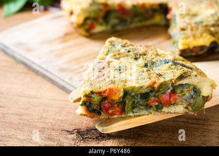 Frittata aus Eier und Gemüse auf Holztisch. Stockfoto