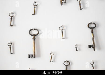 Verschwommenes bild Vintage Style. Schlüssel hängen an der weißen Wand Hintergrund/alten Schlüssel Tapete. Stockfoto