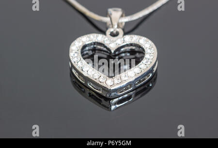 Silber Schmuck Anhänger mit Diamant auf dunklem Hintergrund/Silber Schmuck / Ketten mit Herz Anhänger auf schwarzem Hintergrund / Halsketten mit Herz pen Stockfoto