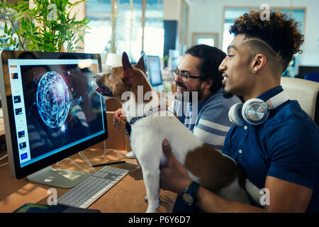 Grafik Designern mit Hund am Computer in die Arbeit im Büro Stockfoto