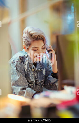 Lächelnden jungen Frau im Gespräch über Smart Phone Stockfoto