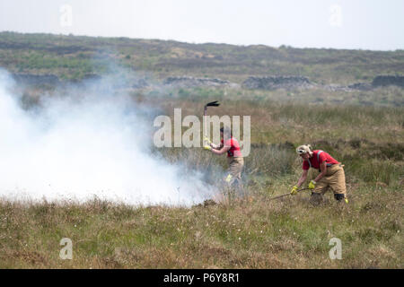 1. Juli 2018 - Weibliche Feuerwehrmänner Einsatz whackers im Winter hILL Feuer zu kämpfen. Feuer Besatzungen aus über Großbritannien haben im Winter Hill konvergierten die Flamme, die Meter pro Stunde wachsen zu steuern. Lancashire Feuer und Rettung und Lancashire Polizei führen die Antwort auf die 'Major Incident'. Stockfoto