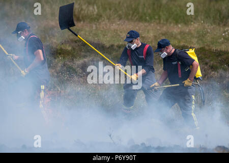 1. Juli 2018 - eine Gruppe von Feuerwehrleuten arbeiten im Winter Hill Feuer zusammen zu kämpfen. Feuer Besatzungen aus über Großbritannien haben im Winter Hill konvergierten die Flamme, die Meter pro Stunde wachsen zu steuern. Lancashire Feuer und Rettung und Lancashire Polizei führen die Antwort auf die 'Major Incident'. Stockfoto