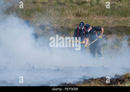 1. Juli 2018 - eine Gruppe von Feuerwehrleuten arbeiten im Winter Hill Feuer zusammen zu kämpfen. Feuer Besatzungen aus über Großbritannien haben im Winter Hill konvergierten die Flamme, die Meter pro Stunde wachsen zu steuern. Lancashire Feuer und Rettung und Lancashire Polizei führen die Antwort auf die 'Major Incident'. Stockfoto