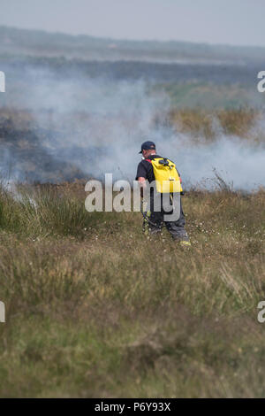 1. Juli 2018 - Feuerwehrmänner Schlacht Flammen auf der Winter Hill Feuer. Feuer Besatzungen aus über Großbritannien haben im Winter Hill konvergierten die Flamme, die Meter pro Stunde wachsen zu steuern. Lancashire Feuer und Rettung und Lancashire Polizei führen die Antwort auf die 'Major Incident'. Stockfoto