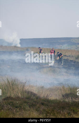 1. Juli 2018 - Feuerwehrmänner Schlacht Flammen auf der Winter Hill Feuer. Feuer Besatzungen aus über Großbritannien haben im Winter Hill konvergierten die Flamme, die Meter pro Stunde wachsen zu steuern. Lancashire Feuer und Rettung und Lancashire Polizei führen die Antwort auf die 'Major Incident'. Stockfoto