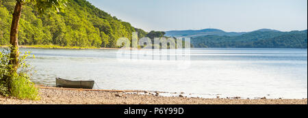 Ein Kanu zog am Strand von Machell Niederwald am nord-östlichen Ende von Coniston Water an einem heißen Sommernachmittag. Stockfoto