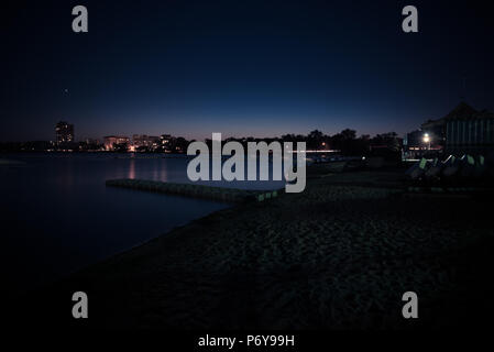 Lange Belichtung eines städtischen See auf einem Sommer Nacht kurz nach Sonnenuntergang. Stockfoto