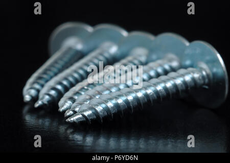 Schrauben der Farbe Silber, sind in einer Reihe auf den Tisch angeordnet Stockfoto