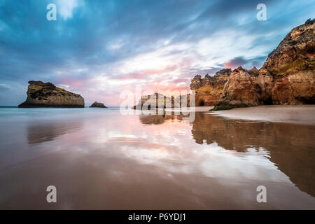 Praia da Rocha, Portimao, Algarve, Portugal. Sonnenuntergang über dem ikonischen Felsformationen an der Küste. Stockfoto