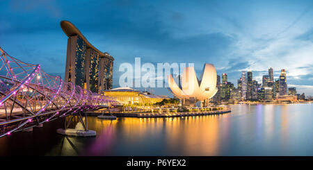 Singapur, Republik Singapur, Südostasien. Panoramablick auf den Helix Bridge, Marina Bay Sands und der ArtScience Museum in der Abenddämmerung. Stockfoto