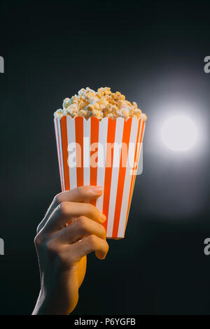 Hand mit Popcorn in gestreiften Löffel an den Film isoliert Stockfoto