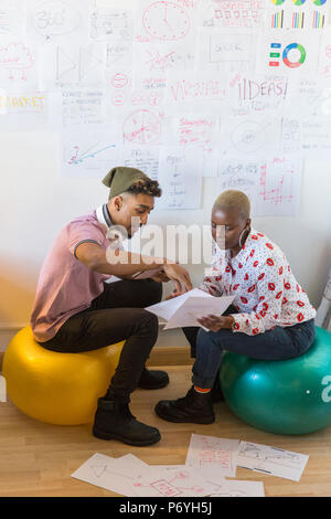 Creative Business Leute auf Fitness Bälle treffen, Brainstorming und Diskussion Unterlagen im Büro Stockfoto