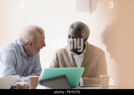 Ältere Unternehmer mit Laptop in Sitzung Stockfoto