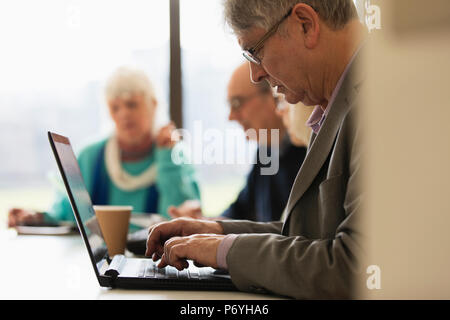 Fokussierte älterer Geschäftsmann mit Laptop im Konferenzraum treffen Stockfoto