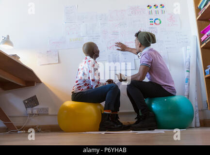 Creative Business Leute auf Fitness Bälle treffen, Schreibarbeit diskutieren Stockfoto