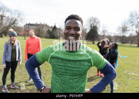Porträt Lächeln, selbstbewusste männliche Läufer im sonnigen Park Stockfoto