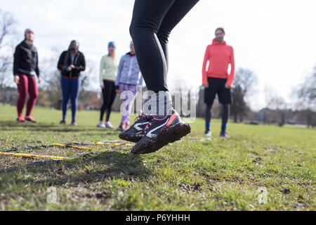 Frau tun Geschwindigkeit Leiter Bohren im sonnigen Park Stockfoto