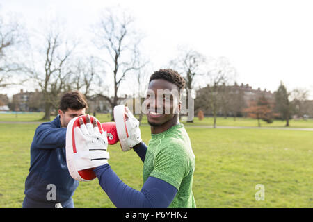 Porträt Lächeln, selbstbewusste Männer boxen in Park Stockfoto