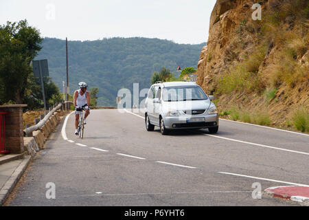 Ein Radfahrer mit 1,5-m-plus deutlich überholen. Girona, Katalonien nördlichen Spanien - Cala Salions. Radfahrer und Pkw auf die GI Corniche Road 682. Stockfoto