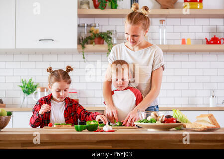 Bild der jungen Mutter mit Tochter und Sohn Kochen am Tisch Stockfoto