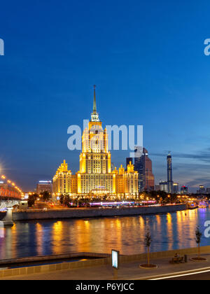 Radisson Royal Hotel Stalinistischen Stil Hochhaus auf der Moskwa bei Einbruch der Dunkelheit beleuchtet. Moskau, Russland. Stockfoto