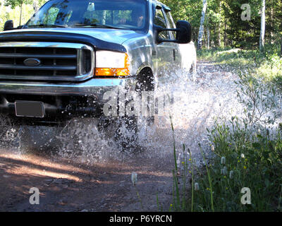 Silber Allradantrieb up Truck Spritzwasser durch Bergbach Bett auswählen Stockfoto