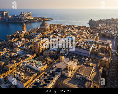 Valletta, Malta - Unsere Liebe Frau vom Berge Karmel Kirche und St. Paul's Cathedral von oben mit Sliema im Hintergrund bei Sonnenaufgang Stockfoto