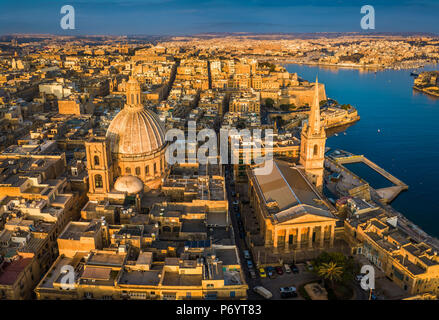 Valletta, Malta - Unsere Liebe Frau vom Berge Karmel Kirche und St. Paul's Cathedral von oben bei Sonnenaufgang mit der antiken Stadt Valletta im Hintergrund Stockfoto