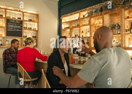 Lächelnd Afrikanische Amerikanische paar Getränke in der Bar genießen. Stockfoto