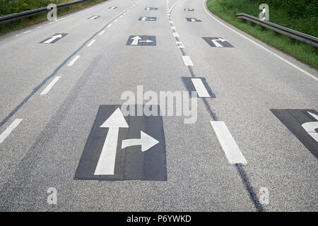 Richtungspfeile auf Asphalt in der Leere Landstraße oder Autobahn gedruckt Stockfoto