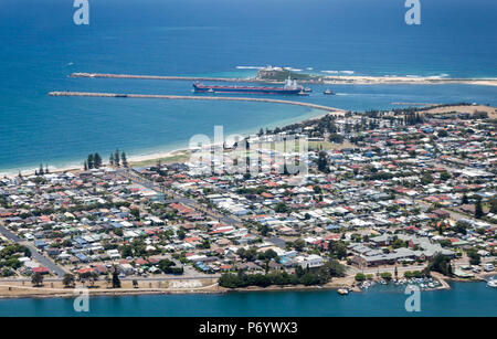 Luftaufnahme einer Kohle Schiff verlässt den Hafen von Newcastle. Die Residental suburb von Stockton können in den Vordergrund mit Nobbys Leuchtturm hinter Th gesehen werden. Stockfoto