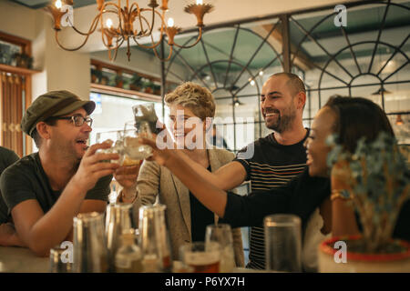 Gruppe von Freunden zujubeln mit Getränken in einer angesagten Bar Stockfoto