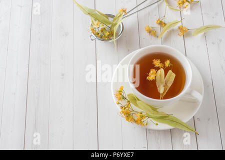 Tasse Tee mit Linden Blumen auf einem Leuchtkasten. Stockfoto