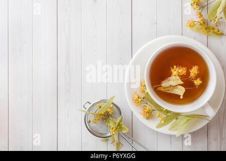 Tasse Tee mit Linden Blumen auf einem Leuchtkasten. Stockfoto