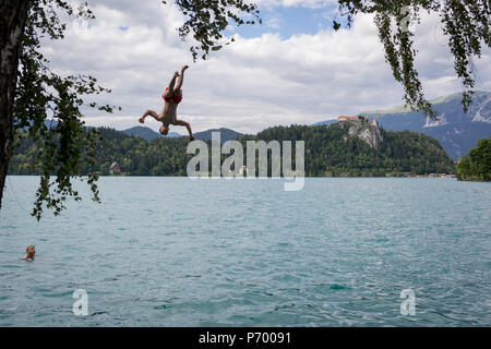 Ein Junge Tauchgänge in das kühle Wasser des Sees Bled, am 18. Juni 2018 in Bled, Slowenien. Stockfoto