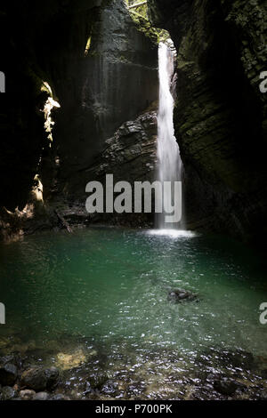 Abenteuerliche Wanderer verhandeln moderates Terrain in der felsigen Schlucht in der Nähe des 15 m hohen Wasserfall Kozjak, Teil der Kobarid Heritage Trail, am 21. Juni 2018, in Kobarid, Slowenien. Stockfoto