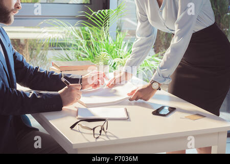Schuß von Geschäftsleuten Signieren von Dokumenten während der Sitzung 7/8 Stockfoto