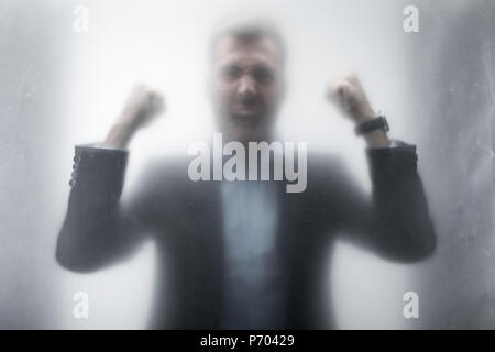 Silhouette von aggressiven Geschäftsmann in Anzug hinter dem Glas schreien Stockfoto
