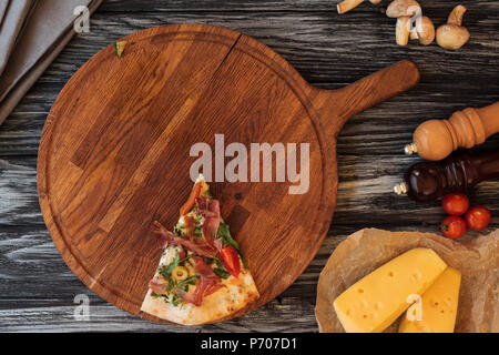 Blick von oben auf die einzige Scheibe leckere Pizza auf Holz Schneidebrett Stockfoto