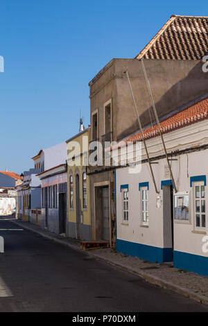 Straße in ein Schatten. Blick auf den kleinen Häusern mit verschiedenen Farben der Fassaden. Strahlend blauen Himmel. Castro Marim, Algarve, Portugal Stockfoto