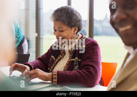 Lächelnd, zuversichtlich senior Geschäftsfrau mit Laptop Stockfoto