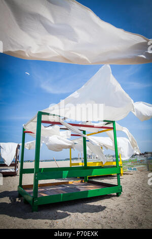 Schuppen Markise mit weißen Vorhängen, der am Ufer des Meeres im Wind. Stockfoto