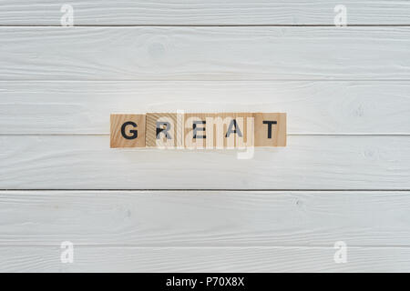 Blick von oben auf die große Inschrift aus Steinen auf weißem Holz- Tischplatte Stockfoto