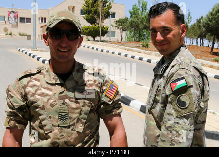 Sgt. 1. Klasse Donald Feder, ein Virginia National Guard Soldat zur 29 Infanterie Division zugeordnet und eine Staff Sergeant vom Jordan bewaffneten Forces-Arab Armee (JAF) Special Operations Command Pose nach Austausch Fahnen ihrer Länder nach der Jordanian-American militärische Fitness Herausforderung, 10. Mai 2017, in der Nähe von Amman, Jordanien. Die Herausforderung bestand aus Luft - Kniebeugen, Sit-ups, Push-ups und burpees. Die Veranstaltung, die für den Rundfunk in den Sozialen Medien aufgezeichnet wurde, hob die körperliche Fitness der beiden Jaf und US-Soldaten und forderte die jordanischen Öffentlichkeit der Soldaten mal zu schlagen. Stockfoto