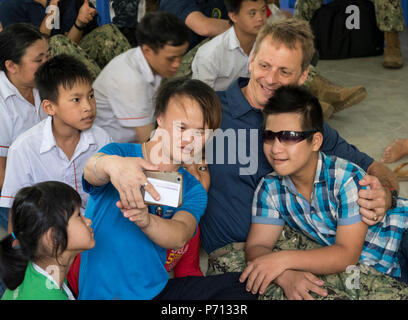 DA Nang, Vietnam (11. Mai 2017) der hinteren Adm. Don Gabrielson, Commander, Logistik Gruppe Western Pacific/Task Force 73, arbeitet mit lokalen Kinder im Zentrum für Agent Orange Opfer Zweig 3 Hoà Nhơn Gemeinde während der Pacific Partnership 2017 Da Nang Mai 11. Pacific Partnership ist die größte jährliche multilaterale humanitäre Hilfe und Katastrophenhilfe Abwehrbereitschaft mission in der Indo-Asia durchgeführt - Pazifik und zielt darauf ab, regionale Koordination in Bereichen wie medizinische Bereitschaft und Vorsorge für synthetische und natürliche Katastrophen zu verbessern. Stockfoto