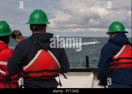 Besatzungsmitglieder der Coast Guard Cutter Eiche Watch vom Bug des Cutter als ihre kleine Crew unterstützt das Fischereifahrzeug Jupiter, die ein Feuer im Maschinenraum, Donnerstag, 11. Mai 2017, in der Nähe von Hyannis, Massachusetts berichtet. Zwei Mitglieder der kleinen Crew an Bord Jupiter und verwendet einen Feuerlöscher, den Schwelbrand. Stockfoto