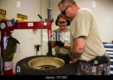 Tech. Sgt. Danielle Stein, links, nach 118 Logistik Bereitschaft Squadron (LRS), und das Personal Sgt zugeordnet. Ty Kilgore, mit 1-230 th Assault Helicopter Bataillon (AHB), arbeiten zusammen, um einen Reifen Felge am 11. Mai 2017, Berry Feld Air National Guard Base, Nashville, Tennessee. Die 1-230 th (AHB) hatte abgefahrene Reifen, die mit einem Luftfahrzeug Zugfahrzeug und nicht die Reifen zu wechseln. 118 (LRS) hat eine Wartung des Fahrzeugs Shop mit den Tools zu ändern reifen Balance und. Stockfoto