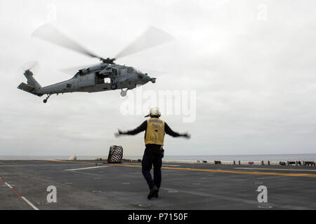 Pazifik (11. Mai 2017) der Luftfahrt Bootsmann Mate (Handling) 3. Klasse Alex Williams, ein Houston Eingeborener, der Abteilung der Amphibisches Schiff USS America zugeordnet (LHA 6), leitet eine MH-60S Seahawk während einer vertikalen Nachschub an den 'Platzhalter' der Heli Attack Squadron 23 zugeordnet. Mehr als 1.800 Segler und 2.600 Marines, die Amerika Amphibious Ready Group (ARG) und dem 15. MEU derzeit eine zusammengesetzte Einheit Übung (COMPTUEX) vor der Küste von Südkalifornien in Vorbereitung auf die Bereitstellung des ARG später dieses Jahr. Amerika ARG Stockfoto